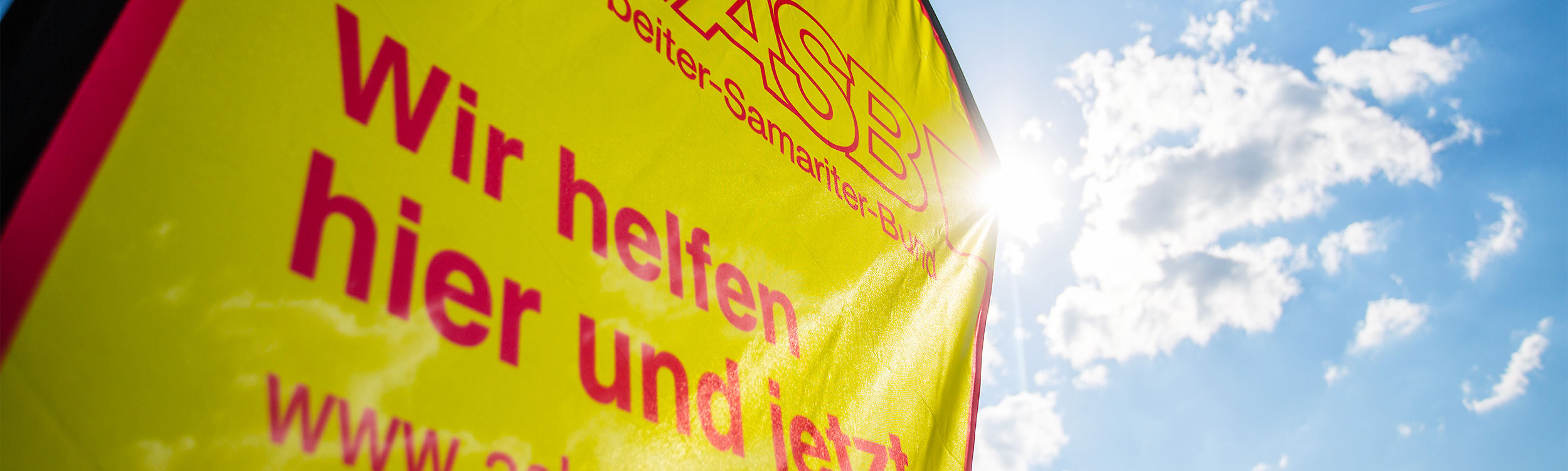 Header, Headerbild, ASB, Beachflag, Himmel, Sonne, Fahne, Fahnen, Flag, Wir helfen hier und jetzt